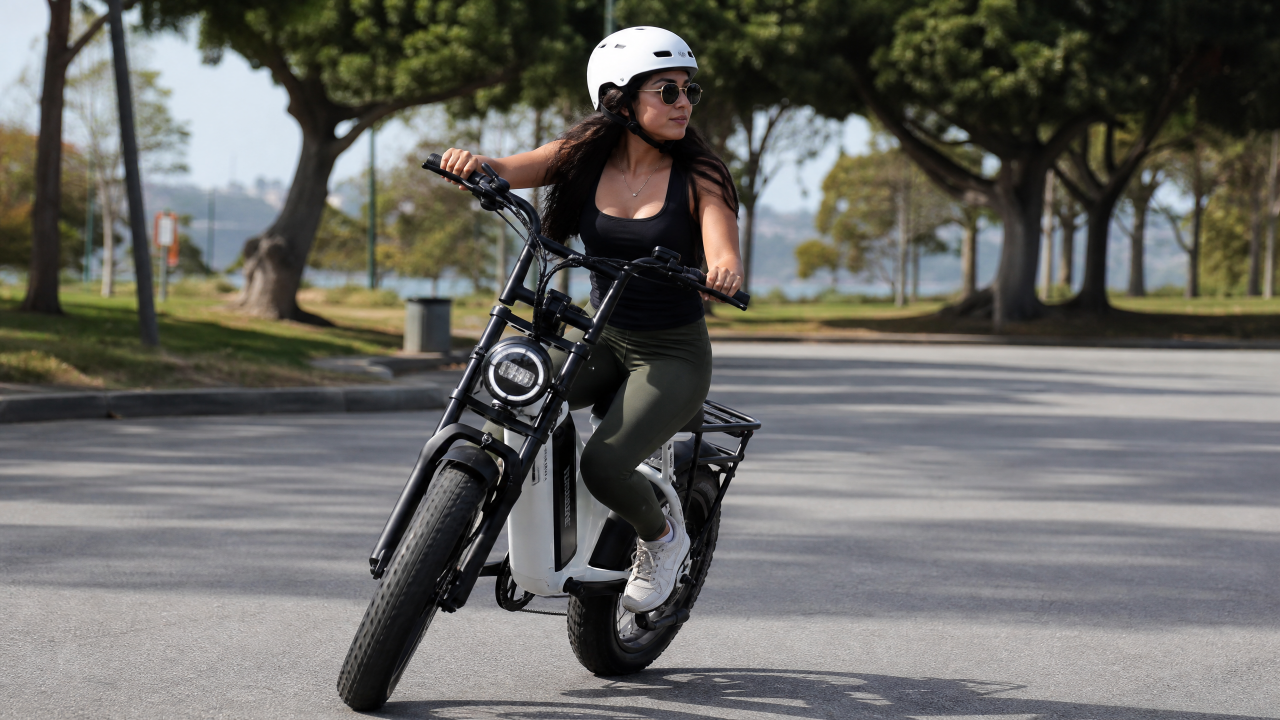 A short woman confidently test-riding an electric bike, making a turn or stopping smoothly.